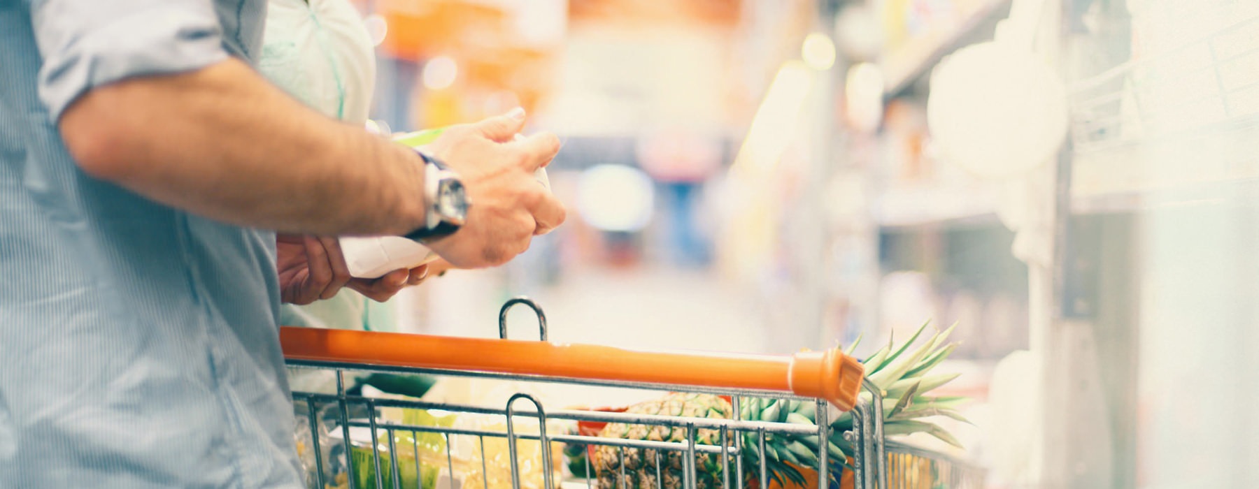 close up of man's full shopping cart in neighborhood grocery store